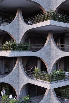 an apartment building with multiple balconies and plants growing on the balconies