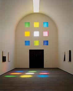 an empty room with several different colored squares on the wall