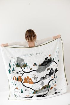 a woman is holding up a blanket with a map on it that says national parks