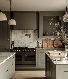 a kitchen with gray cabinets and marble counter tops