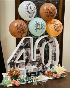 a table topped with balloons and a sign that says 40