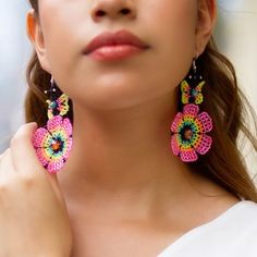 a close up of a person wearing some kind of earring with flowers on it