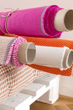 three rolls of fabric are hanging on a rack