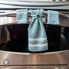 a blue crocheted towel hanging from the handle of an oven