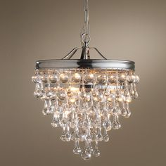 a chandelier hanging from the ceiling with clear glass beads and chrome fittings