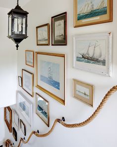 there are many framed pictures on the wall with rope hanging from it's side