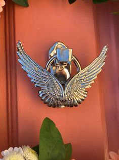 a close up of a door handle with flowers in the foreground and an image of a bird on it