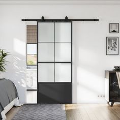 a bedroom with a bed, dresser and sliding glass door