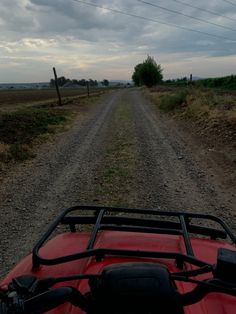 a red atv driving down a dirt road