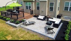 a patio with chairs, tables and an umbrella