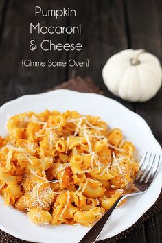 pumpkin macaroni and cheese on a white plate with a fork next to it