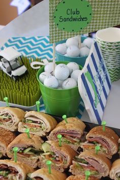 a table filled with sandwiches and golf balls