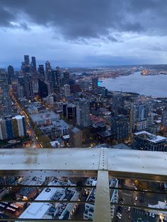 an aerial view of a city at night from the top of a building with lots of tall buildings