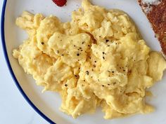 scrambled eggs on a plate with toast and strawberries