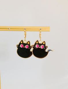 Unveil the spirit of Halloween with our Black Cat Ghost Earrings. A bewitching fusion of charm and spookiness, these earrings feature intricately designed mini black cat and ghost motifs. Crafted with attention to detail, they embody the essence of the season. The lightweight, comfortable huggie style ensures a secure fit for all festivities. Perfect for Halloween parties or adding an eerie touch to your style, these earrings capture the playful mystique of the holiday. Whether you're a cat love Cat And Ghost, Black Cat Ghost, Cat Ghost, Bottle Earrings, Halloween Black Cat, Ghost Earrings, Ghost Cat, Sparkly Earrings, Halloween Black