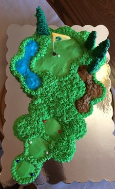 a cake shaped like a golf course on top of a white tablecloth with green frosting