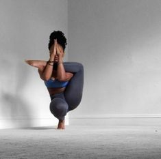 a woman is doing yoga on the floor with her hands behind her head and legs crossed