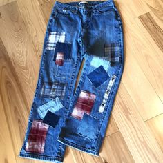 an old pair of jeans with patchwork on the bottom and side, sitting on a wooden floor