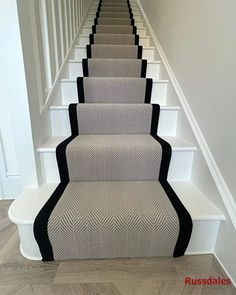 the stairs are lined with black and white carpet