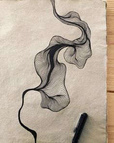 a piece of paper with a drawing on it next to a pen and some ink