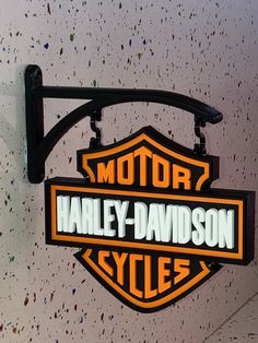 the harley davidson cycles sign is mounted to the side of a wall in a garage