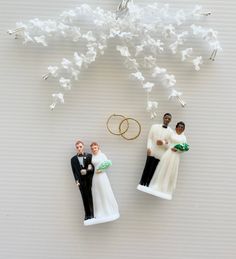 wedding cake toppers are arranged in the shape of two brides and one groom