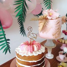 there is a cake with pink frosting on the table next to other desserts