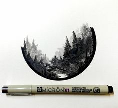 a pen is sitting on top of a piece of paper next to a drawing of trees