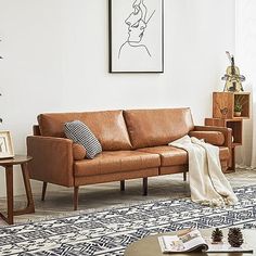 a living room with a couch, table and pictures hanging on the wall above it