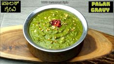 a metal bowl filled with green food on top of a wooden board