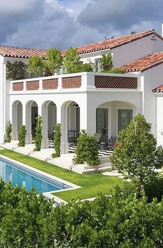 a large white house with a pool in front of it