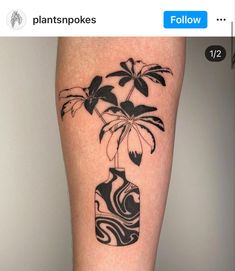 a black and white flower vase tattoo on the leg