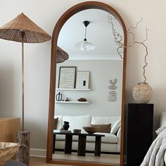 a living room filled with furniture and a large mirror