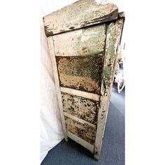 an old wooden door that has been painted white and brown with peeling paint on it