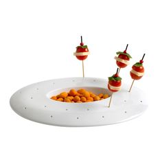 there is a plate with food on it and three skewers in the shape of apples