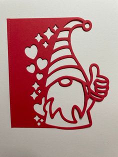 a red paper cut out of a santa clause