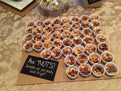 there are many small cups with nuts in them on the table next to a sign that says, i am nuts