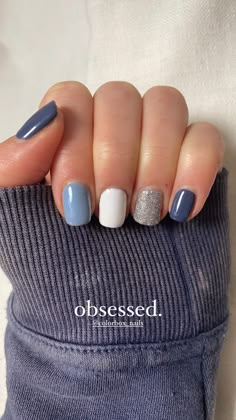 a person with blue and white nail polish on their fingers, holding onto a sweater