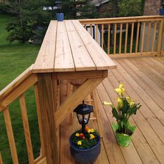 a potted plant sitting on top of a wooden deck next to a lamp post