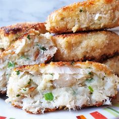 three chicken patties on a plate with parmesan cheese and green onion sprinkles