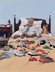 an old man laying in bed with many toys