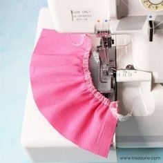 sewing machine with pink dress on top of it and clock in the backgroound