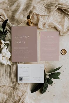 the wedding stationery is laid out on top of a blanket with flowers and greenery