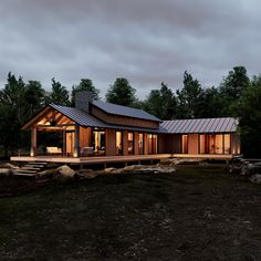 a house with a covered porch in the middle of some rocks and trees around it