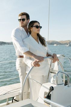 a man and woman standing on the deck of a boat