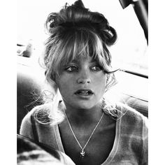 a black and white photo of a woman sitting in the back seat of a car