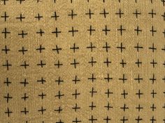 the fabric has crosses on it in black and tan colors, as well as an off - white background