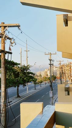 an empty city street with power lines and telephone poles on the side of the road