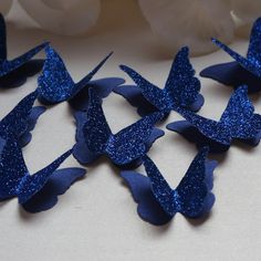 blue glittered paper butterflies on a white table