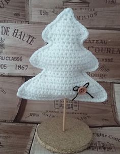 a crocheted white christmas tree on a wooden stand